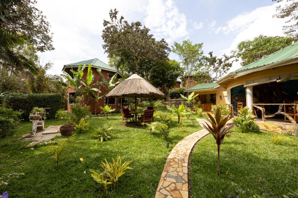 un jardin avec une maison et une pelouse dans l'établissement Africa Safari Arusha, à Arusha