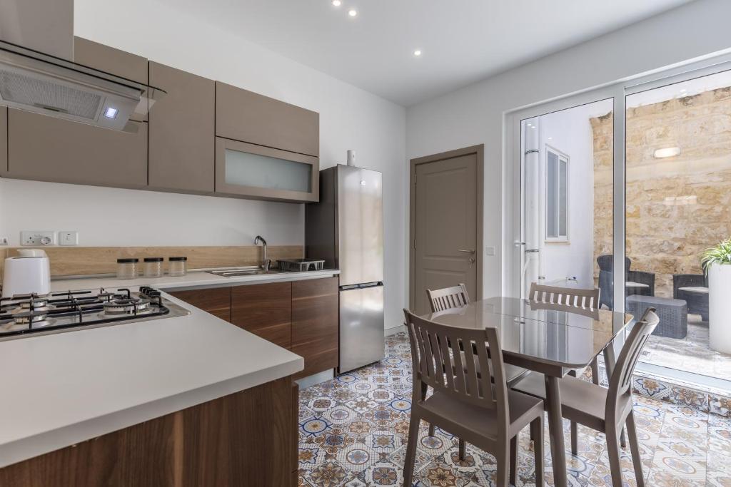 a kitchen with a table and chairs and a kitchen with a counter at Town House Luqa in Luqa