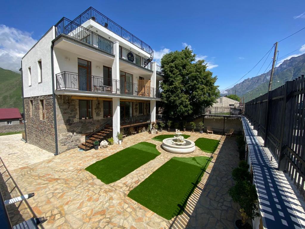 uma casa com uma fonte no meio de um quintal em Mood Hotel Kazbegi em Kazbegi