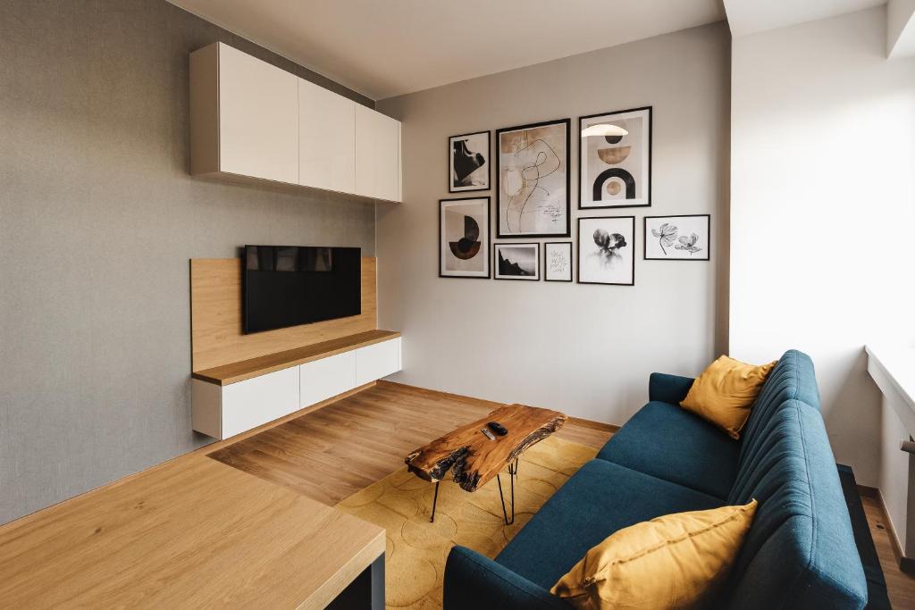 a living room with a blue couch and a television at Apartment FRIENDs Bratislava in Bratislava