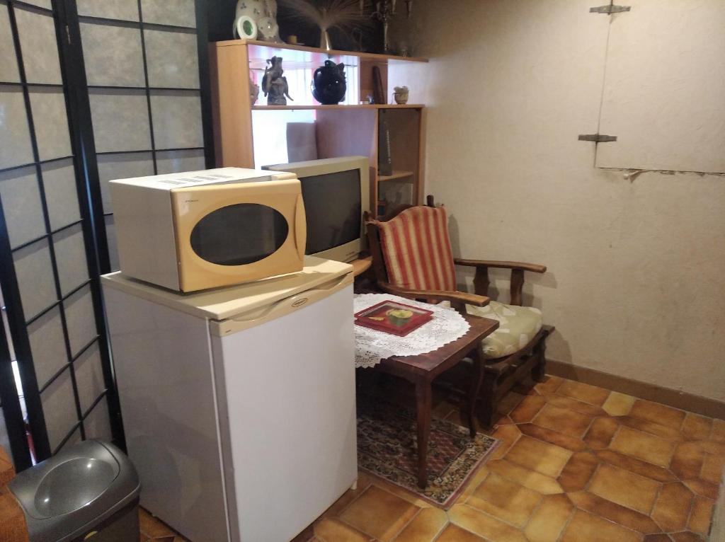 einen TV auf einem Kühlschrank im Wohnzimmer in der Unterkunft Charmante chambre d&#39;hôte in Sigean