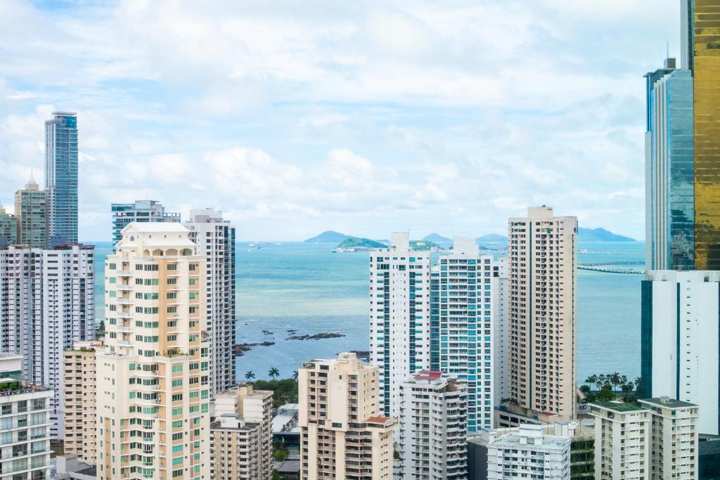 a view of a city with tall buildings and the ocean at Riu Plaza Panamá in Panama City
