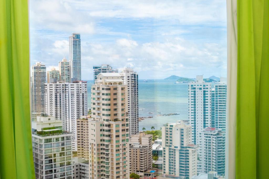 a view of a city with buildings and the ocean at Riu Plaza Panamá in Panama City