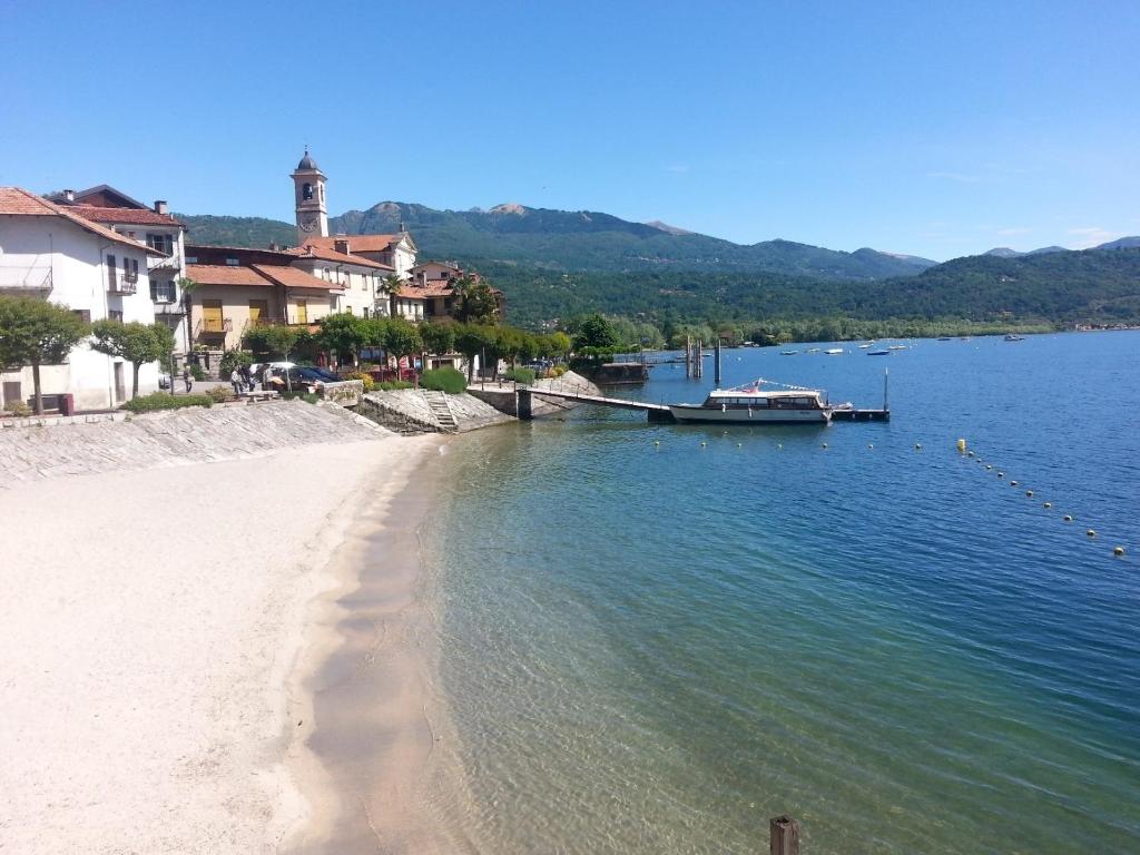 a boat is docked on a beach next to the water at Appartamento Caretto in Baveno