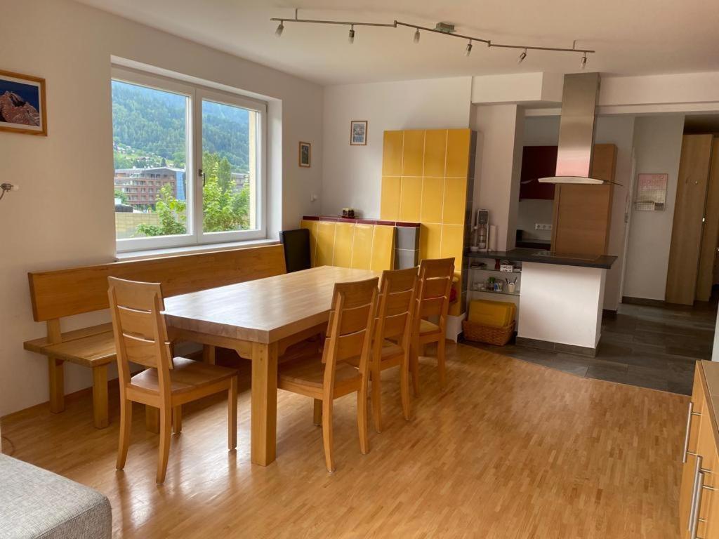 eine Küche und ein Esszimmer mit einem Holztisch und Stühlen in der Unterkunft Deluxe Apartment DONNA in Schladming