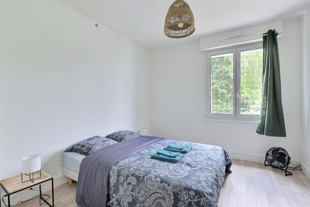 een witte slaapkamer met een bed en een raam bij Le Dugois centre-ville Belfort in Belfort