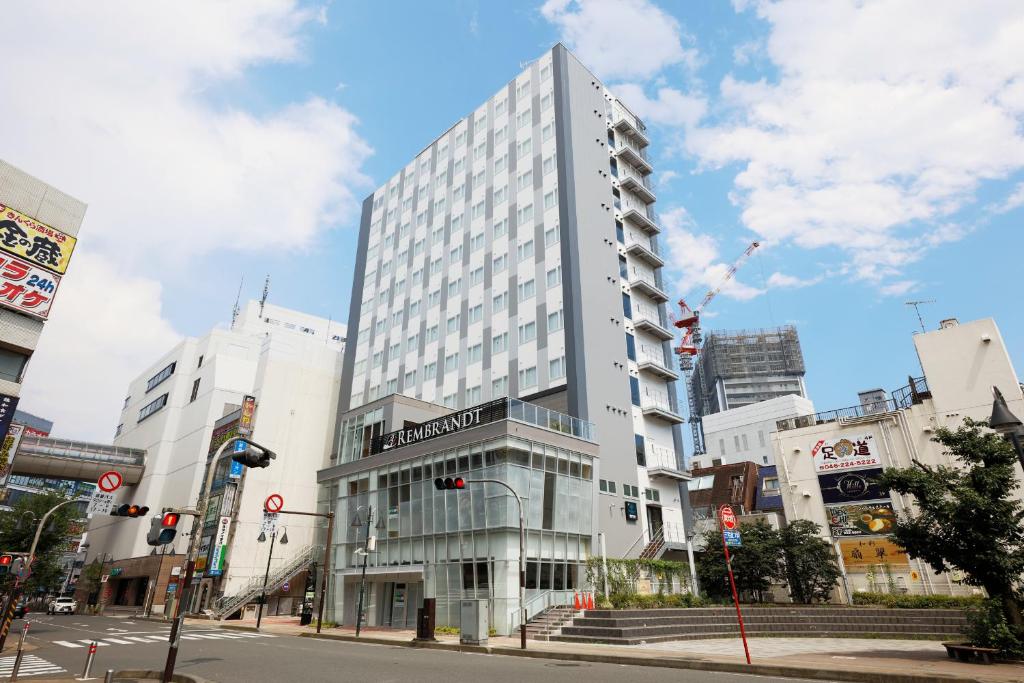 un edificio blanco alto en una calle de la ciudad en Rembrandt Style Honatsugi, en Atsugi