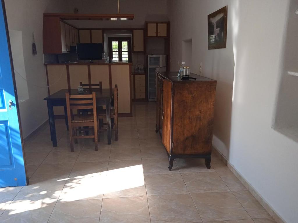 una cucina e una sala da pranzo con tavolo e sedie di EVANTHIA S HOUSE a Katákoilos