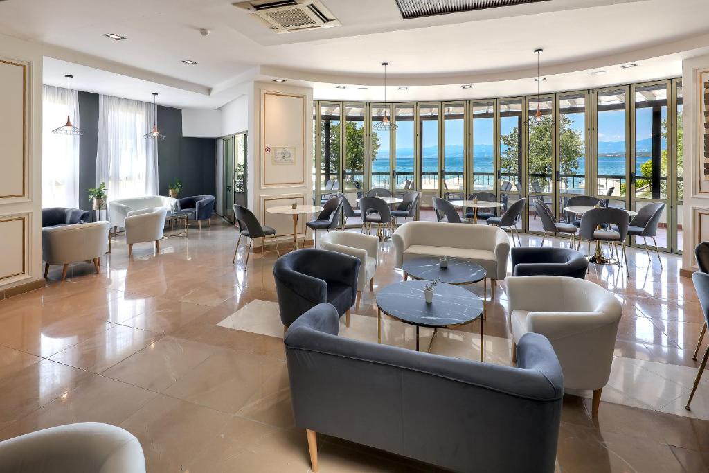 a lobby with couches and tables and windows at Blue Waves Resort in Malinska