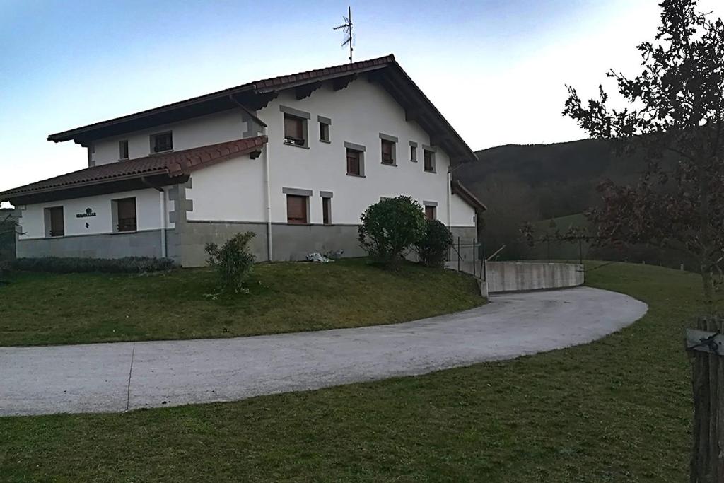 uma grande casa branca com uma estrada em frente em Casa Rural Sarobetxea en Larrayoz, Navarra 