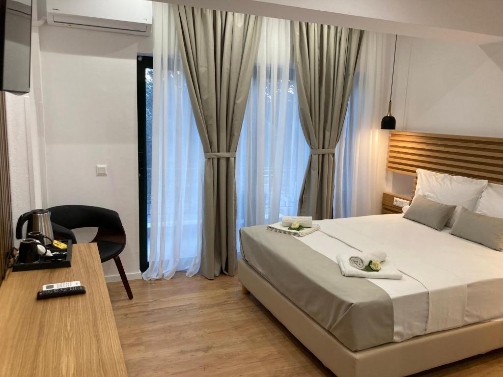 a bedroom with a bed and a table and a chair at Ampoulos Rooms & Apartments in Kedro