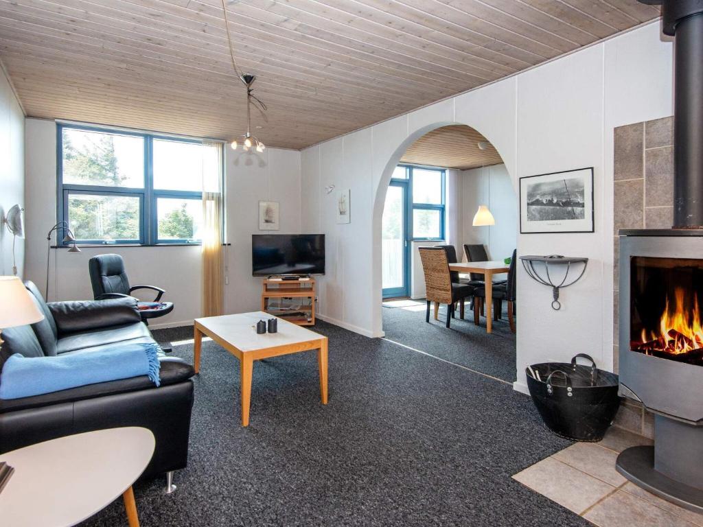 a living room with a couch and a fireplace at 6 person holiday home in Hvide Sande in Havrvig