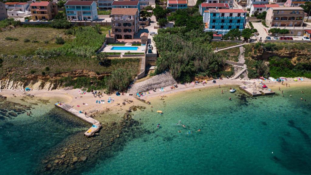 an aerial view of a beach with people in the water at Pool and Beachfront Apartment Ena - Perfect Family Escape in Pag