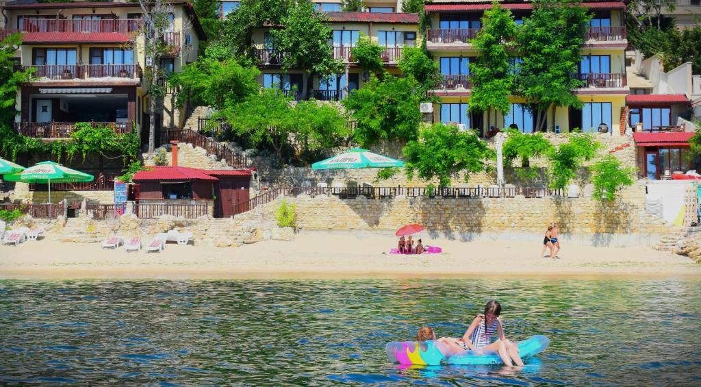 dwie osoby na tratwie w wodzie w pobliżu plaży w obiekcie Morski Briag Hotel w Złotych Piaskach
