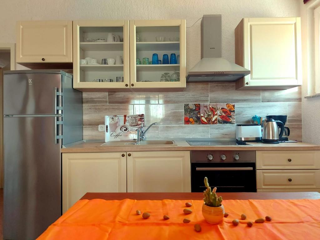 een keuken met witte kasten en een oranje tafel bij Panorama Pakoštane in Pakoštane