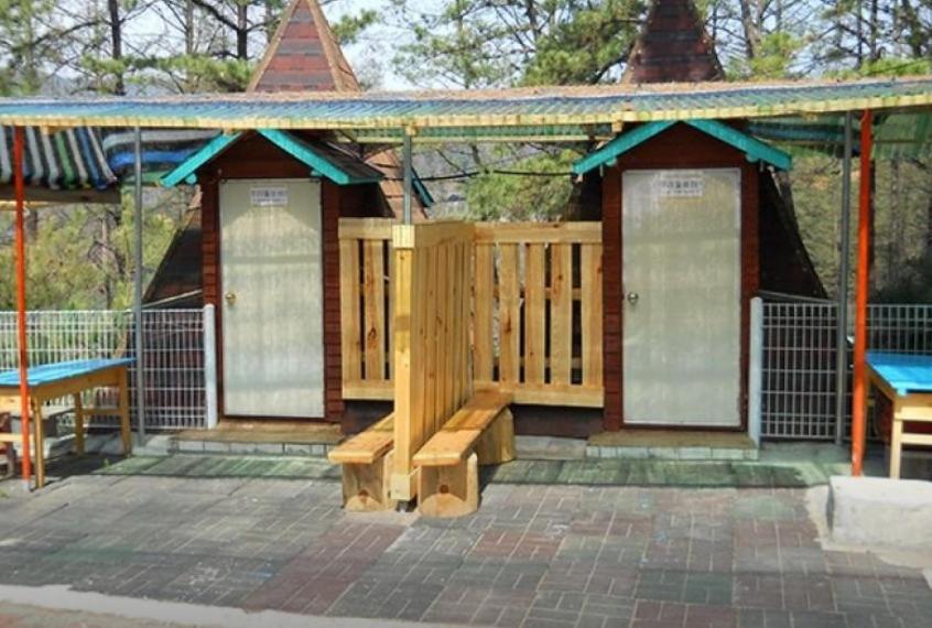 a wooden deck with a bench and a pavilion at Yeongwol Healing Forest Pension in Yeongwol