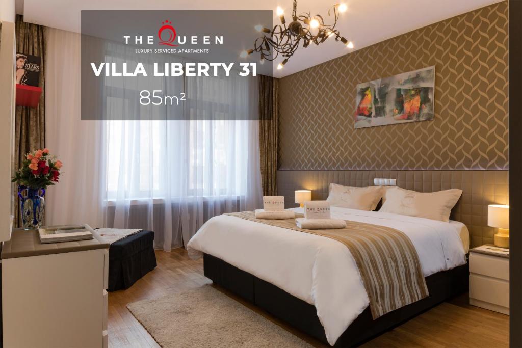 Habitación de hotel con cama grande y lámpara de araña. en The Queen Luxury Apartments - Villa Liberty, en Luxemburgo