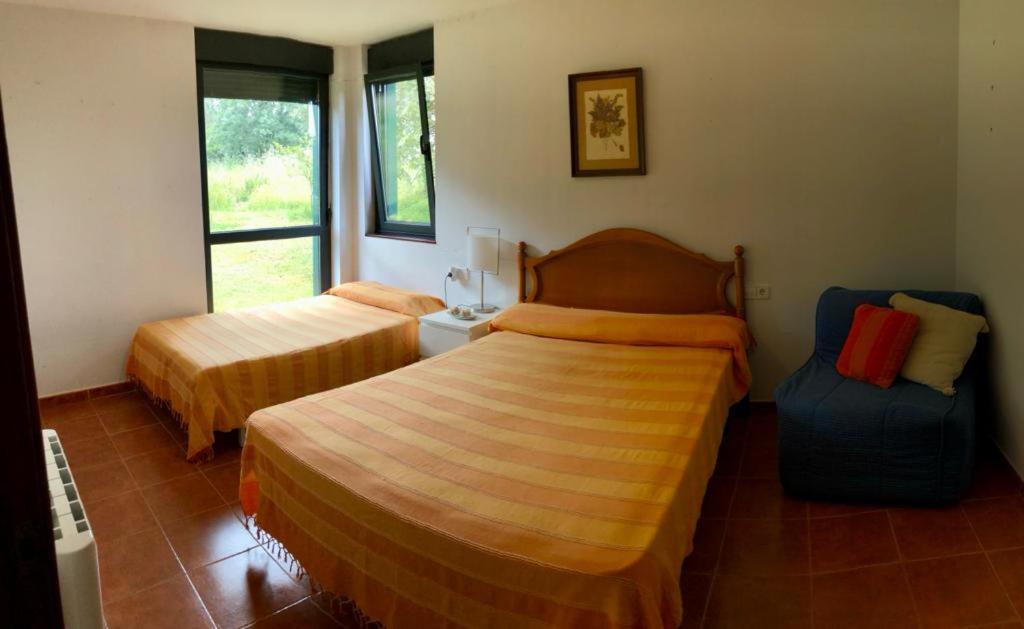 Pokój hotelowy z 2 łóżkami i krzesłem w obiekcie Los Robles-PLAYA COROSO w mieście Ribeira
