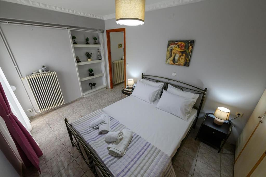 een slaapkamer met een bed met handdoeken erop bij Spacious Apartment with Patio in Kalamata