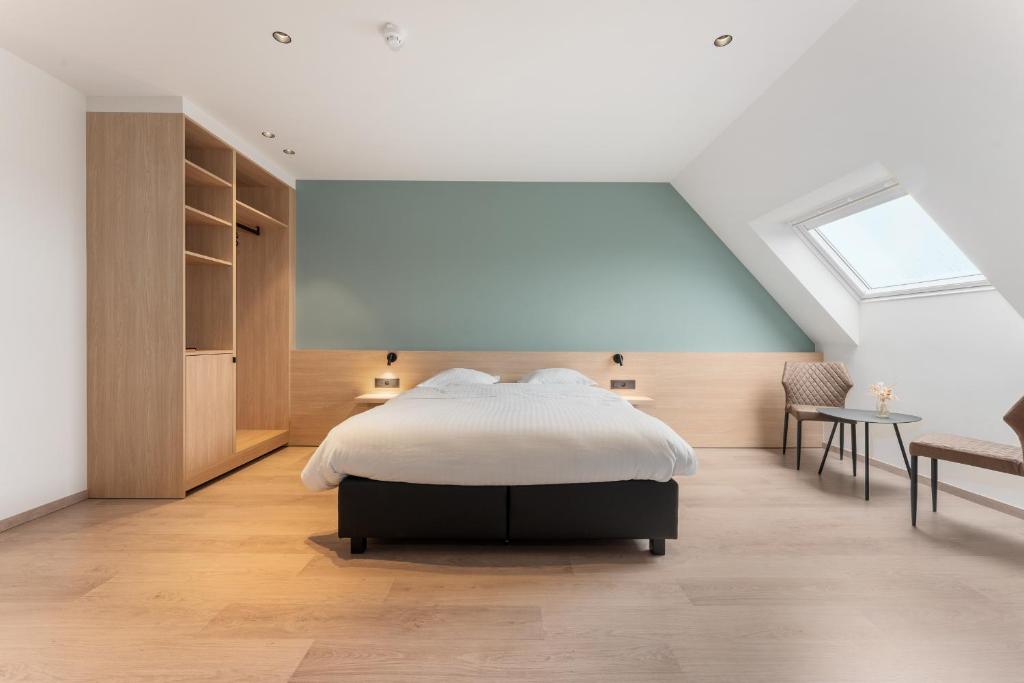 een slaapkamer met een bed en een dakraam bij Hof Ter Molen - Luxe kamer met privé badkamer in Diksmuide
