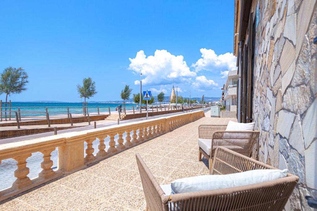 una fila di sedie su un marciapiede accanto alla spiaggia di Villa Molinar a Palma de Mallorca