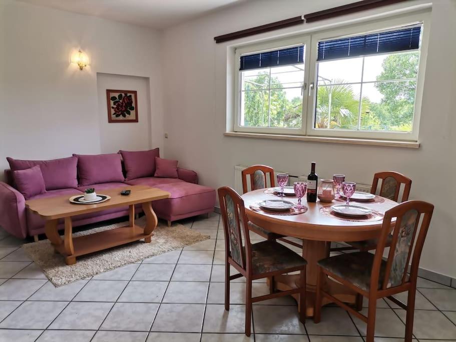 uma sala de estar com uma mesa e um sofá roxo em Haus MARE - entspannen & sonnenbaden em Viskovo