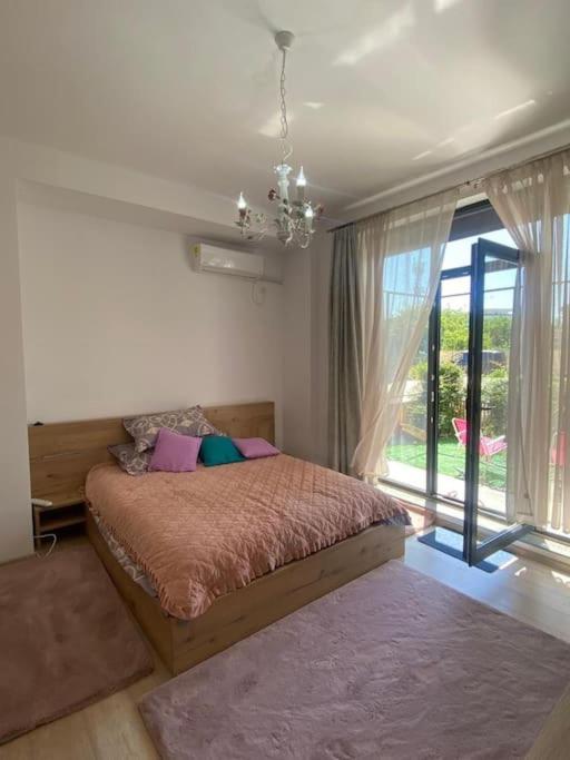 - une chambre avec un lit et une grande fenêtre dans l'établissement Seaside retreat. two room apartment. quiet area, à Năvodari