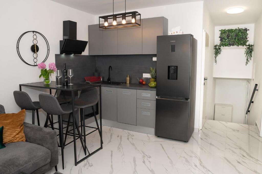 a kitchen with a refrigerator and a table with chairs at Apartment Adam in Zadar