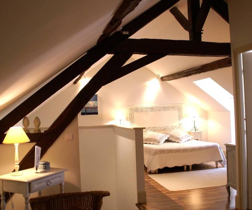 a bedroom with a white bed in a attic at Gîte de la corgette in Saint-Romain