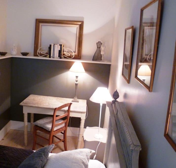 a room with a table and a chair and a table with a mirror at Gîte de la corgette in Saint-Romain