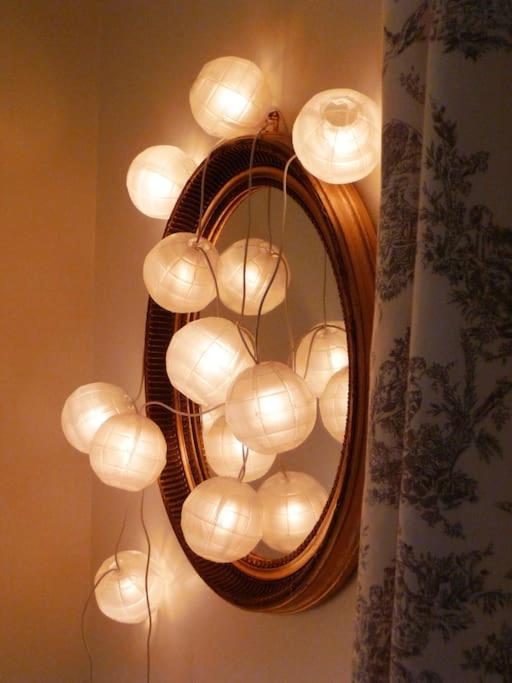 a mirror with a bunch of lights on a wall at Gîte de la corgette in Saint-Romain
