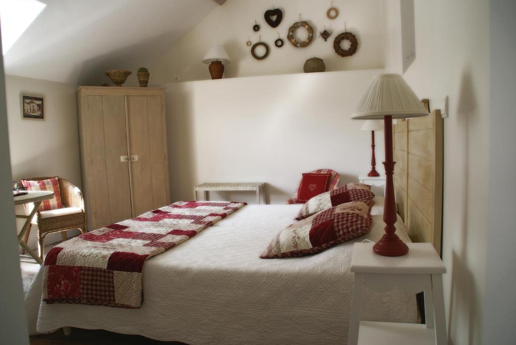 a bedroom with a bed with a lamp on a table at Gîte de la corgette in Saint-Romain