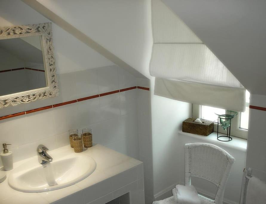 a white bathroom with a sink and a mirror at Gîte de la corgette in Saint-Romain