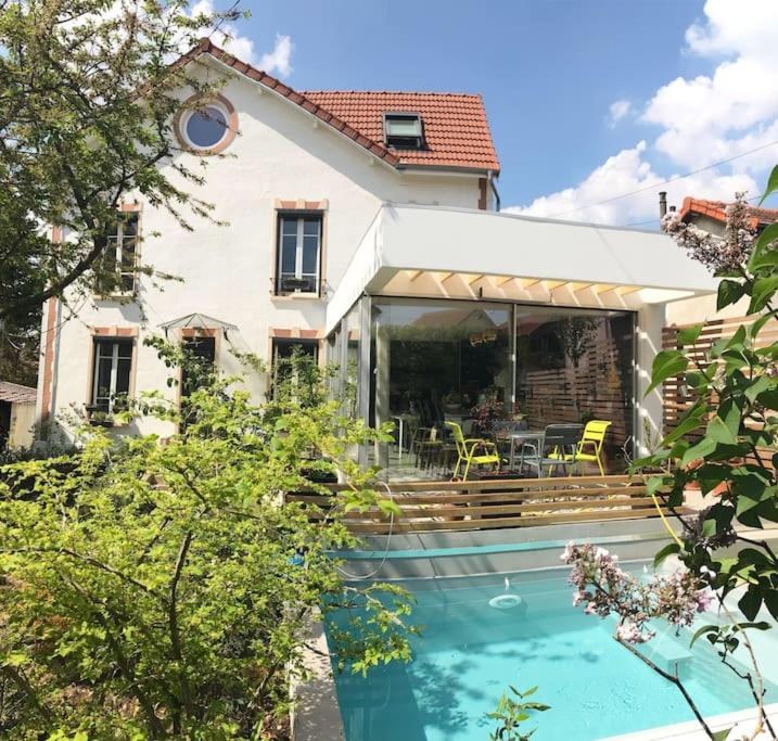uma casa com piscina em frente a uma casa em Proche Paris et Disney, maison avec piscine sauna em Sucy-en-Brie