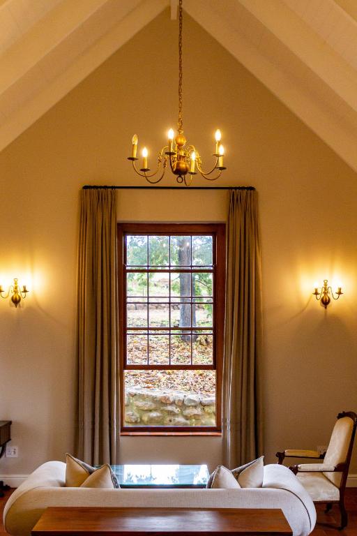 a bedroom with a bed and a window at Plaisir Estate Accommodation in Simondium