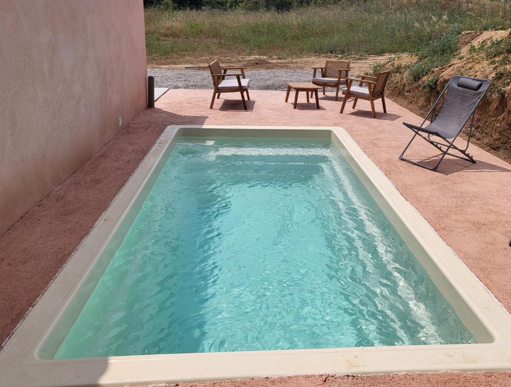 - une piscine avec des chaises, une table et des chaises dans l'établissement Gite Capparone 1, à Bastelicaccia