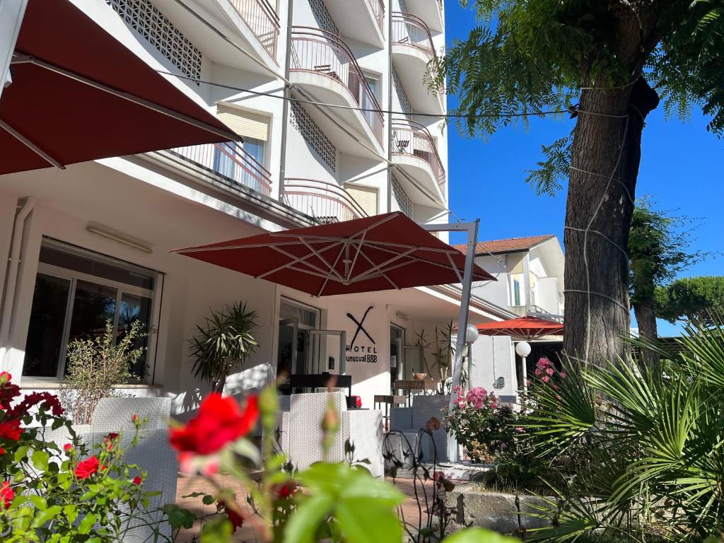 un edificio con dos sombrillas rojas delante de él en X Hotel, en Punta Marina