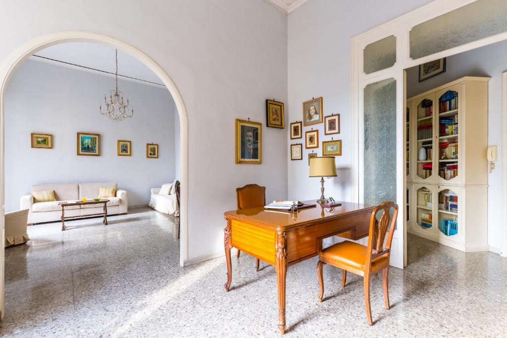 sala de estar con escritorio de madera y silla en Rettifilo Family Apartment by Wonderful Italy, en Nápoles