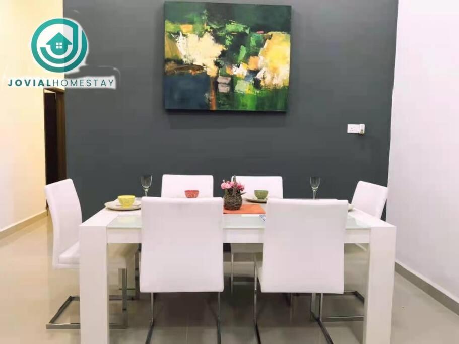 einen weißen Esstisch mit weißen Stühlen und einem Gemälde in der Unterkunft Modern COZY HOUSE 3 ROOM 6PAX@ ALMA JUSCO.BM in Bukit Mertajam