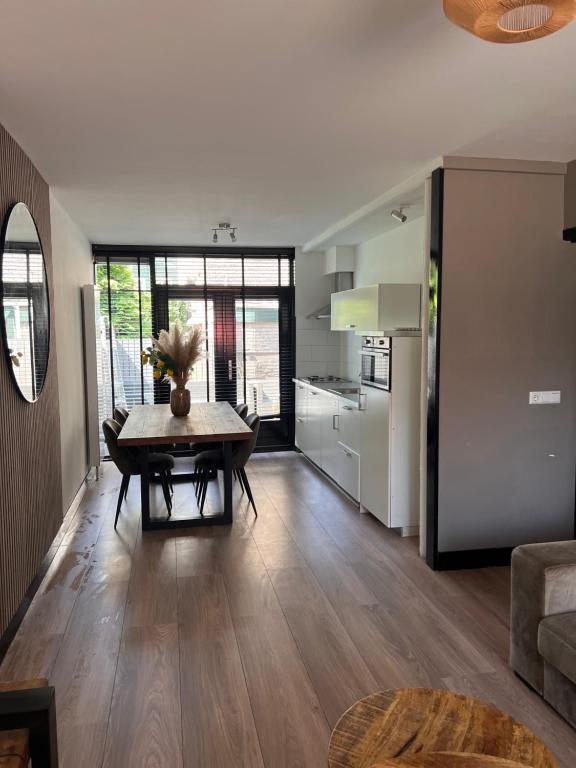 ein Wohnzimmer mit einem Tisch und einer Küche in der Unterkunft Casa Xabia in Zaandam