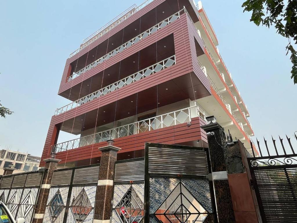 un edificio alto con una valla delante en SRH HOTEL, en Greater Noida