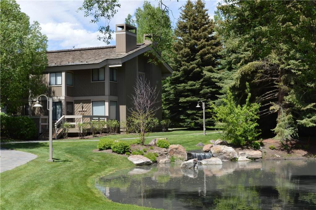 ein Haus mit einem Teich vor einem Haus in der Unterkunft Creekside Condo 1296 - Bright & Sunny for 6 Guests with Resort Pool Included in Sun Valley