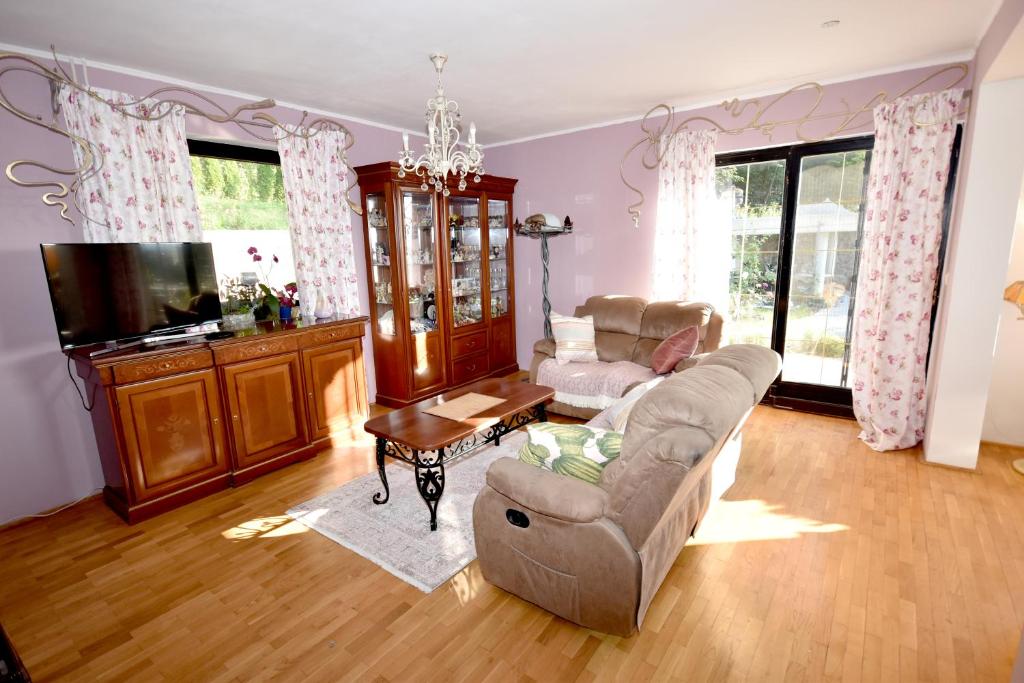 a living room with a couch and a tv at apartmaji LEJARDIN in Škofljica