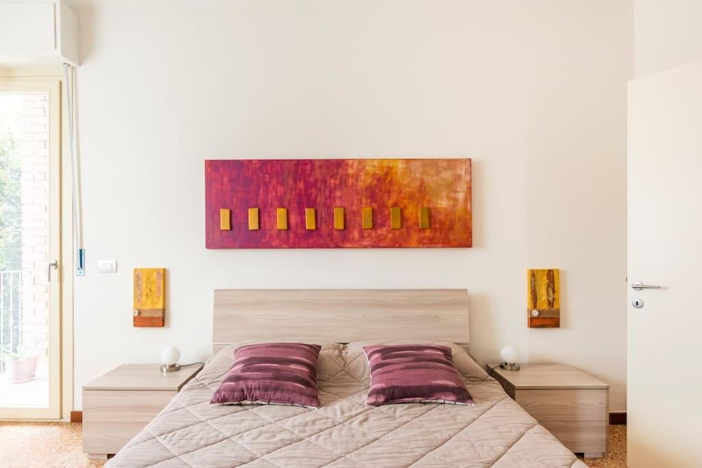 a bedroom with a bed and a painting on the wall at CASA TILDE Barbaresco in Barbaresco