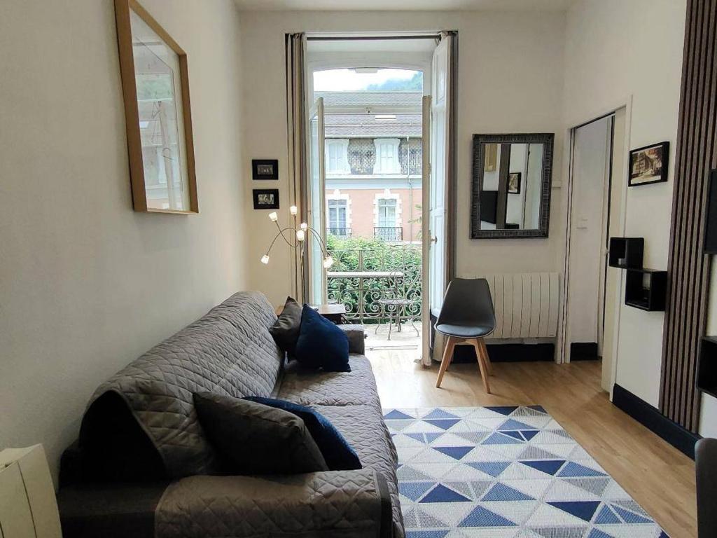 un salon avec un canapé et une fenêtre dans l'établissement Charmant T2 avec balcon pour 2 pers à Cauterets, tout équipé, proche pistes - FR-1-234-306, à Cauterets