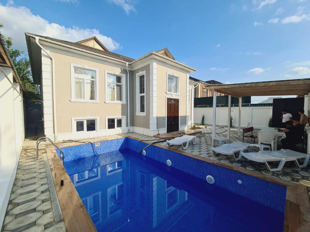 a house with a swimming pool in front of a house at Yasin White villa in Gabala