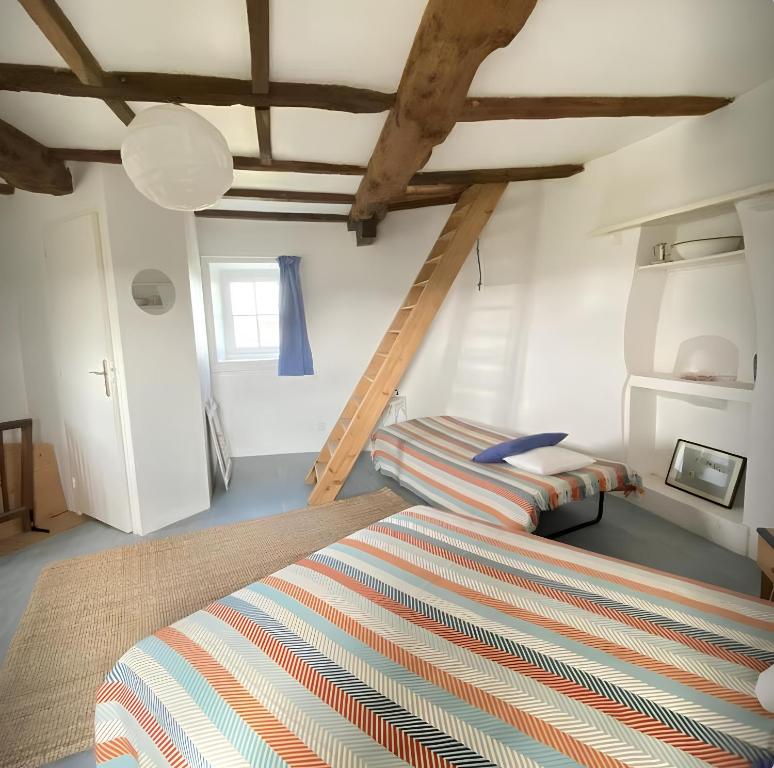 um quarto com uma cama num quarto com tectos em madeira em Ancien moulin à vent du 19e siècle em Cherrueix