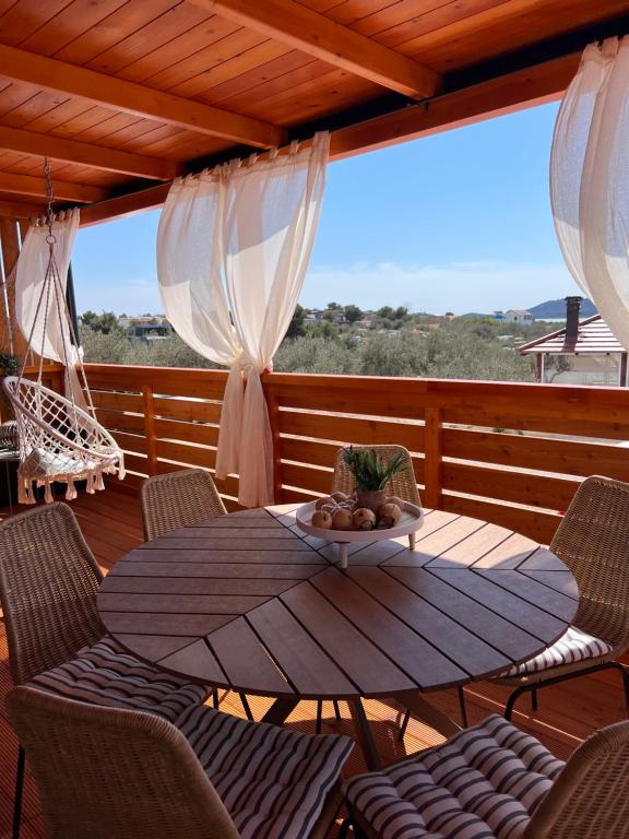 a wooden deck with a table and chairs on a porch at Green Turtle Holiday - Lovely, brand new holiday home near the sea in Drage