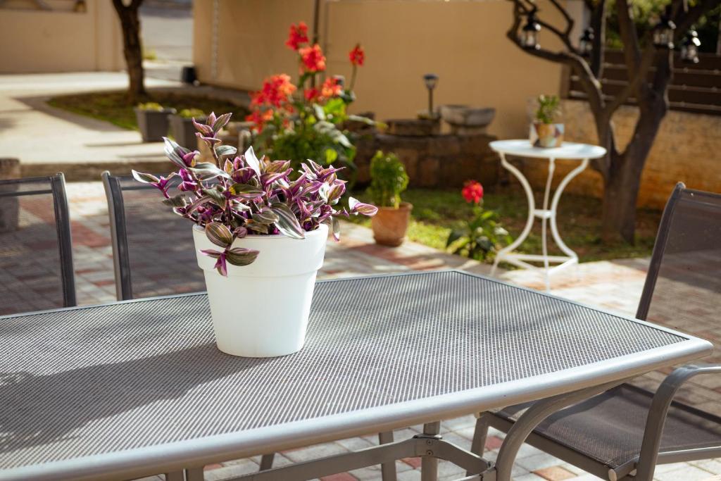 a white vase with flowers sitting on a table at Plakoures Home in Kounoupidhianá