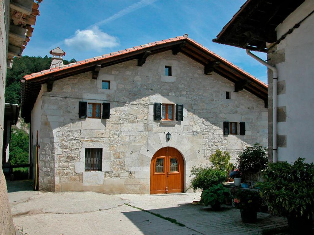 een groot stenen huis met een bruine deur bij Casa Rural Pierresena en Larrayoz, Navarra in Arístregui